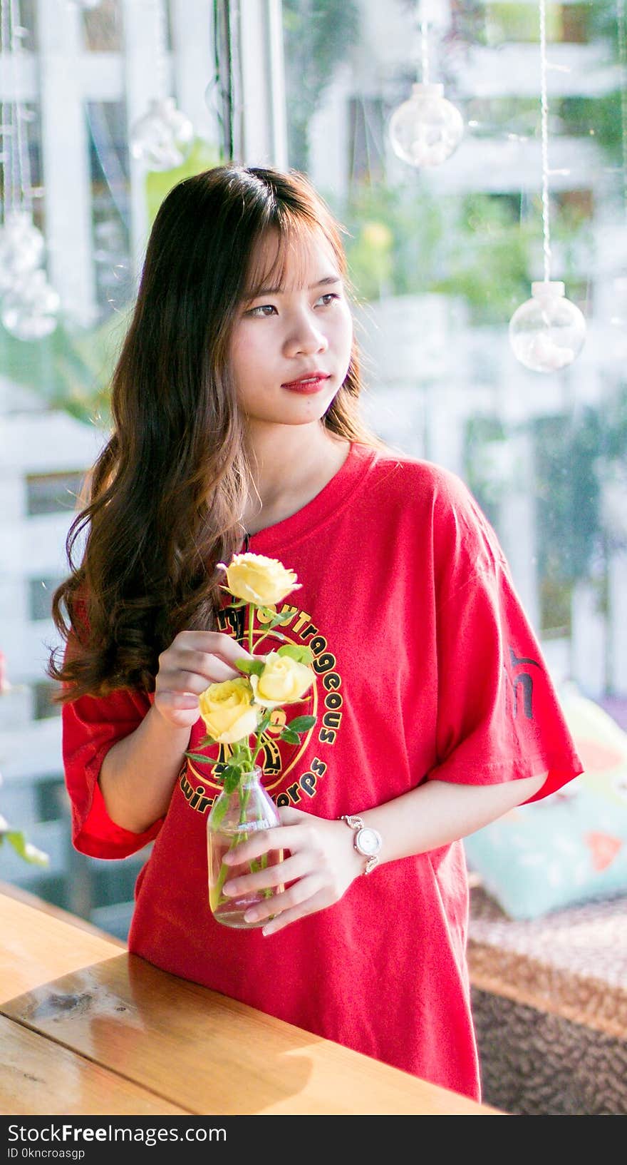 Woman Wearing Pink Scoop-neck Shirt While Holding Yellow Flowers