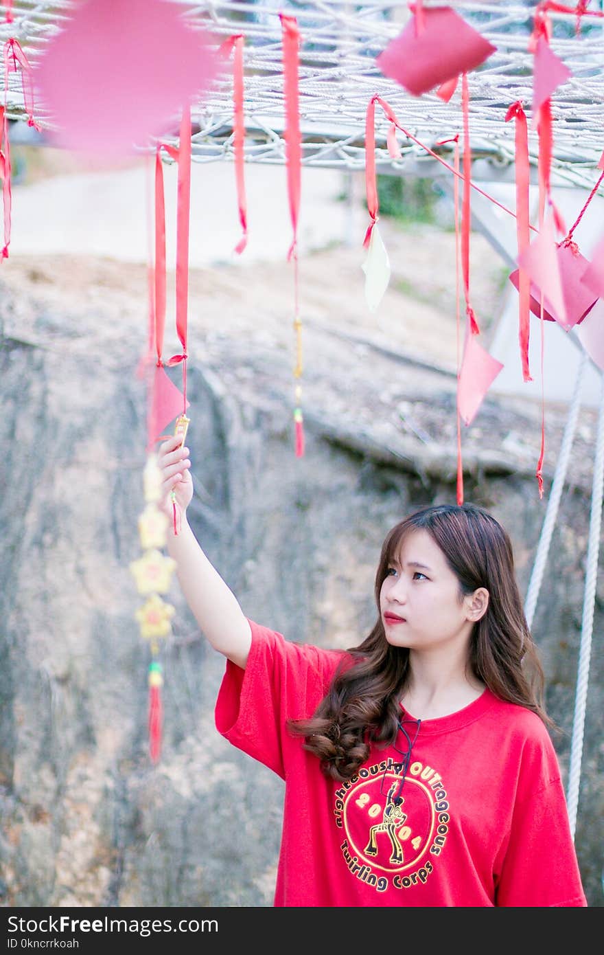 Woman Wearing Red Crew-neck Shirt Near Gray Wall