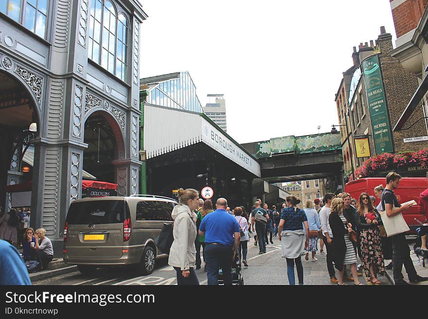 People on Gray Road Surrounded by Buildings