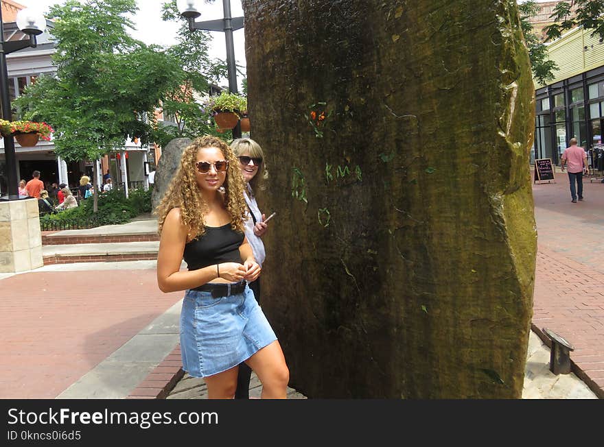 Women Standing Near Brown Monolith