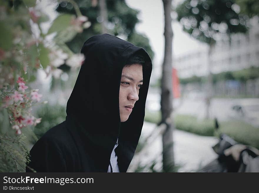 Man Wearing Black Hoodie Jacket Standing Near Pink Flowers