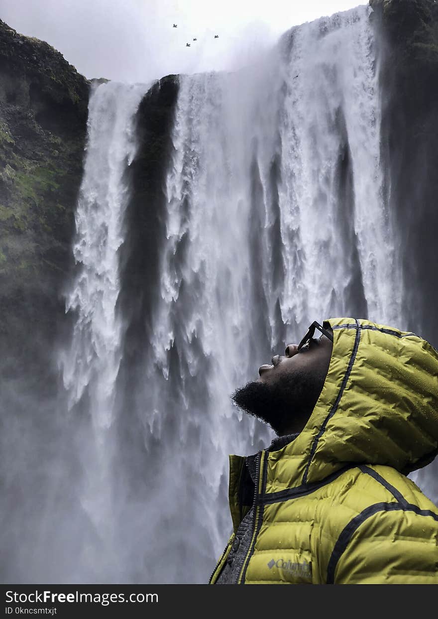 Photography of Man Wearing Bubble Hoodie Jacket Near Waterfalls