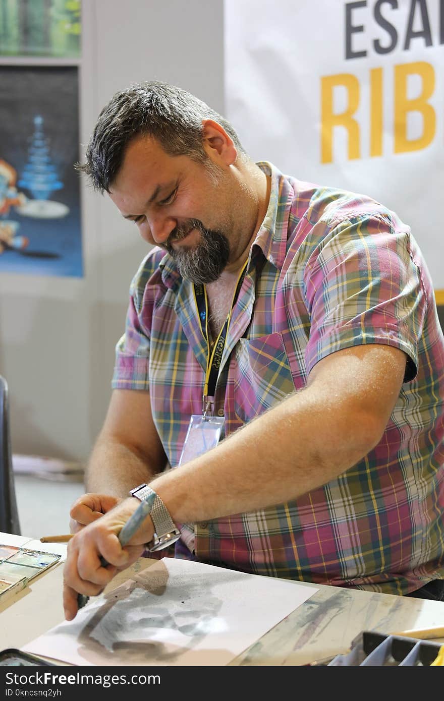 Man Wearing Pink Checkered Shirt While Sketching