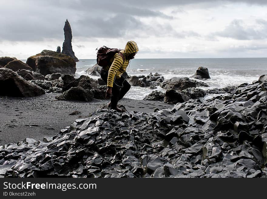 Photo of Man in Yellow Hoodie Near Seashore