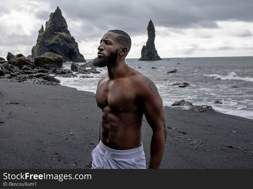 Man Wearing White Bottoms Near Body of Water