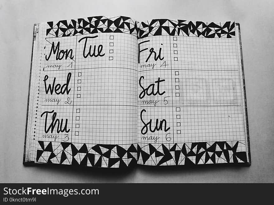 White and Black Weekly Planner on Gray Surface