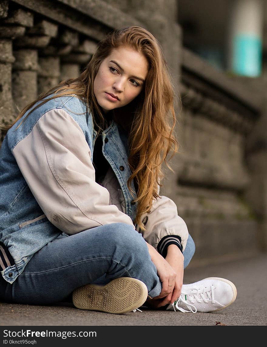 Brown Haired Woman Sitting Beside Gray Concrete Railings