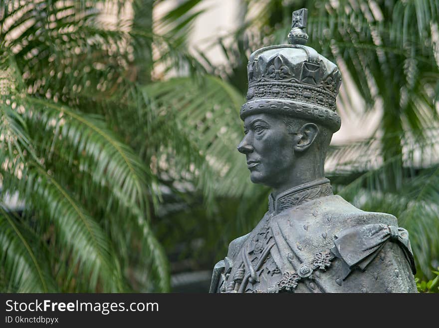 Male Statue Near Green Palm Trees at Daytime