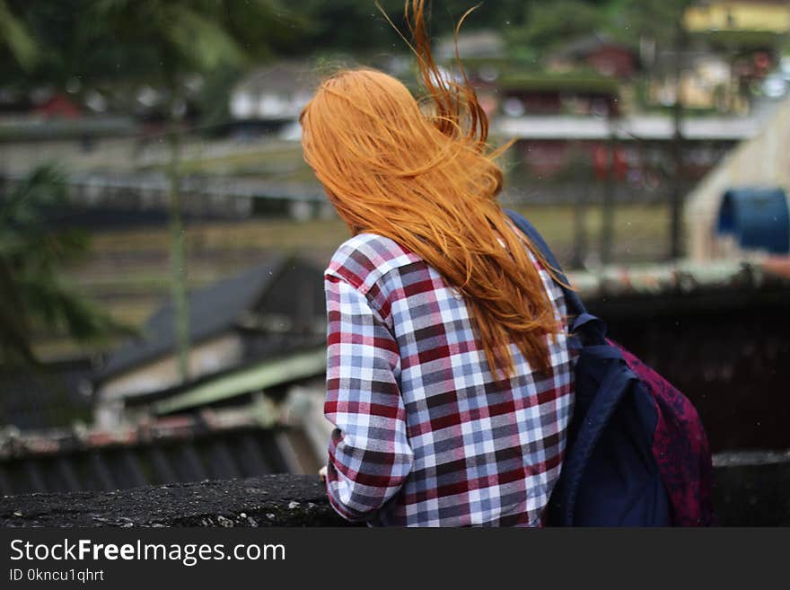 Person in White and Red Checkered Top With Black and Red Backpack in Shallow Focus Photography