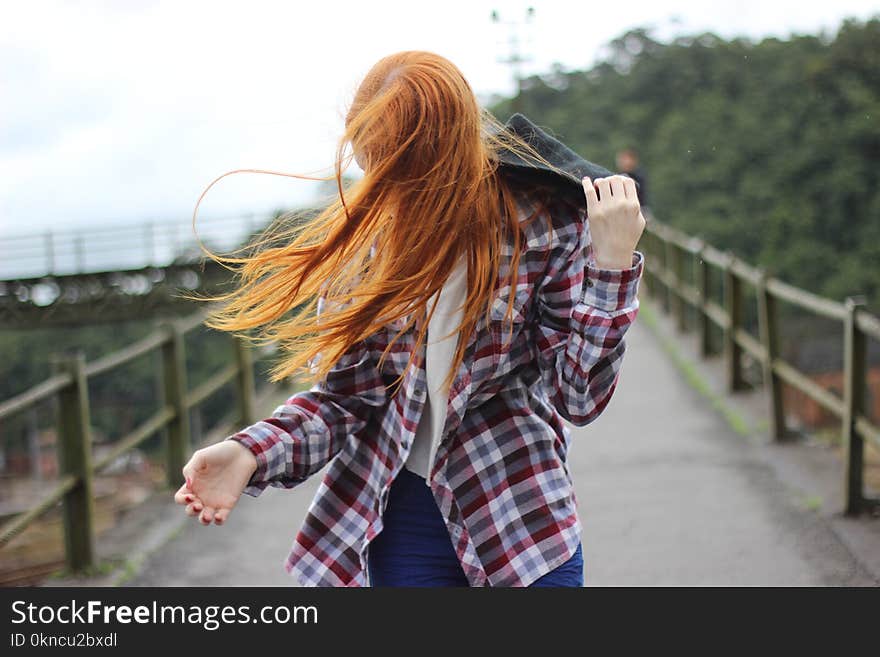 Woman Wearing Plaid Button-up Sport Shirt While Holding Black Hood