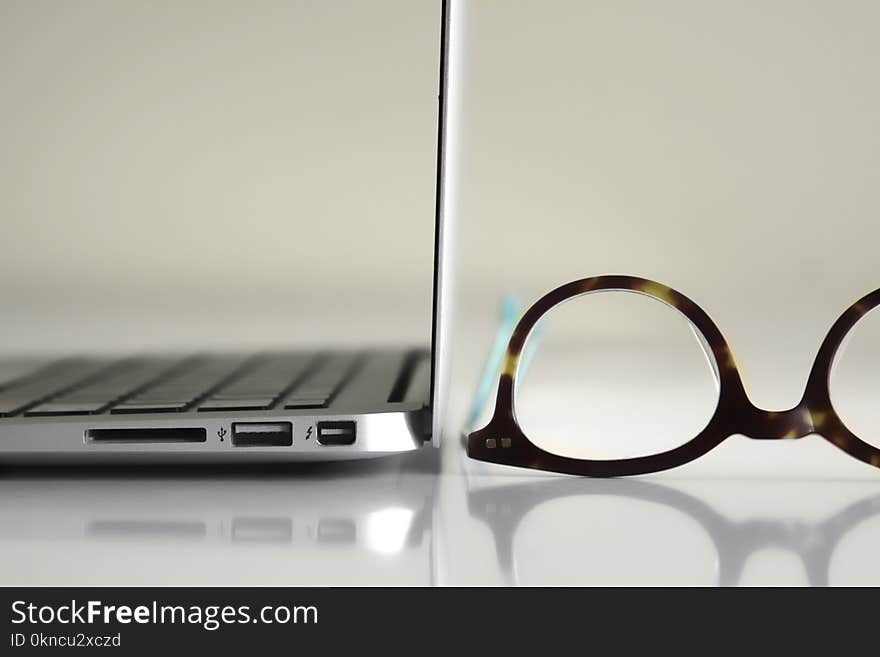 Black Framed Eyeglasses Beside Laptop Computer