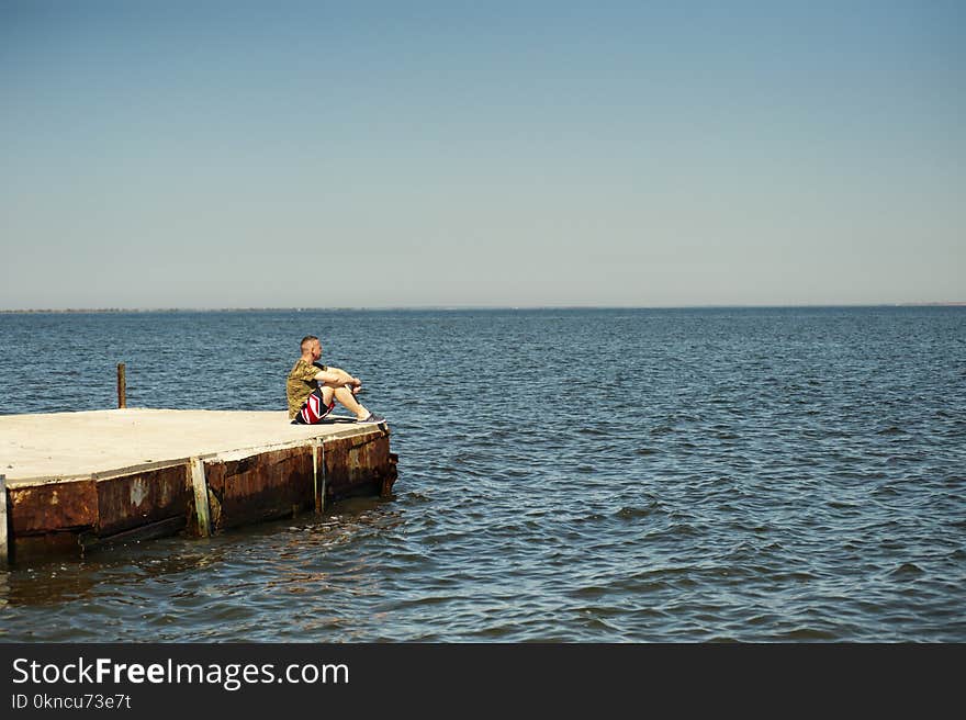 Man Sitting on Dock