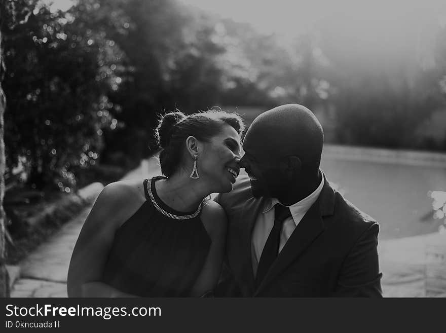 Grayscale Photo of Couple at Garden Near Pool