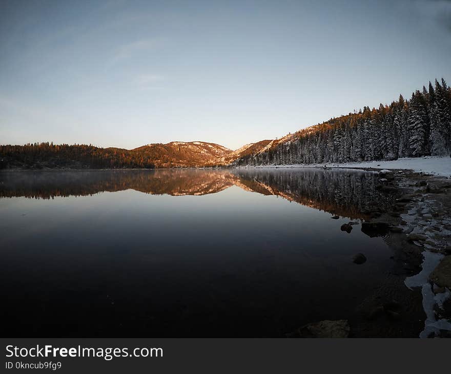 Reflection of Mountain and Trees on Body of Water