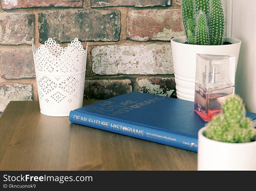 Blue Book on Brown Wooden Table with flower vases