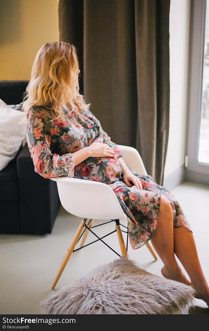 Pregnant Woman Sitting on Armchair Holding Her Tummy