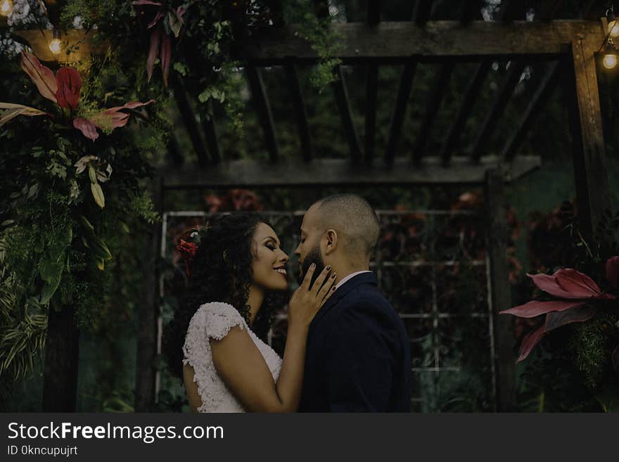 Couple Under Garden Arch Surrounded With Flowers