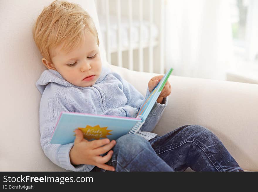 Cute baby boy holding book