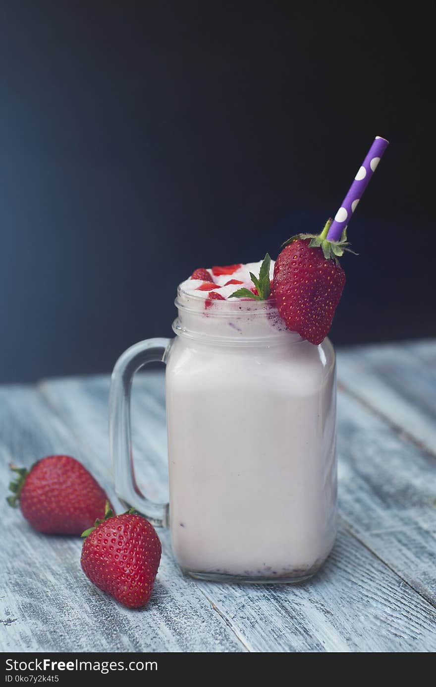 Milk Cocktail Shake Drink with Srawberry. homemade Fruit Milkshake with Straw in Glass. Rustic Gray wooden Background.