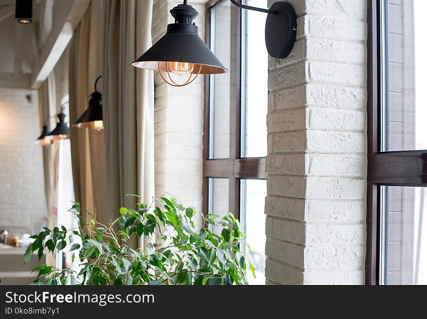 A lamp on the background of a window and a wall with curtains.