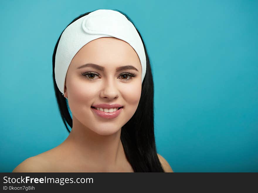 Portrait of smiling woman wearing white cosmetological headbandage.Waiting for beaty salon procedures and professinal master. Smoth, young, healthy skin. Beatiful face. Feeling happy, satisfied.