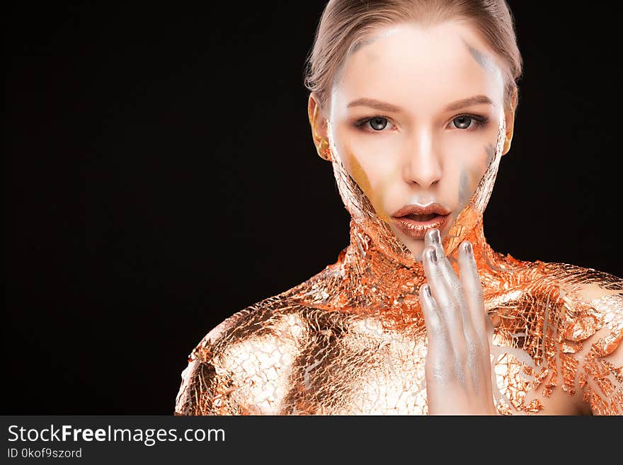 Beauty portrait of lovely blonde woman with creative makeup and golden foil on her shoulders. Space for text. Beauty portrait of lovely blonde woman with creative makeup and golden foil on her shoulders. Space for text