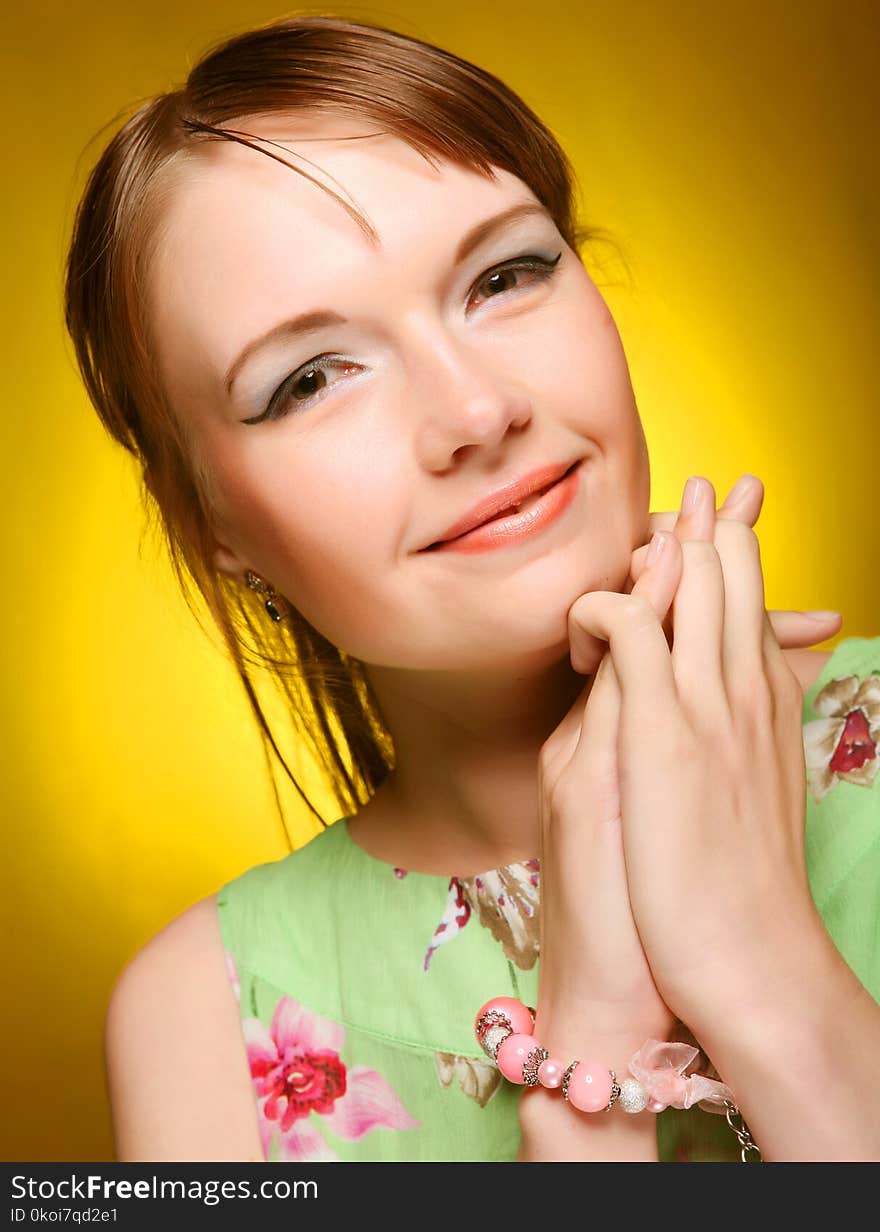 Beautiful young woman face on yellow background. Beautiful young woman face on yellow background