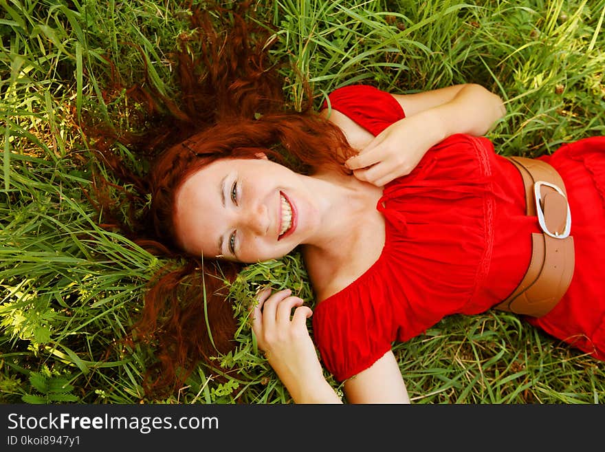 Young beautiful girl lays on a grass