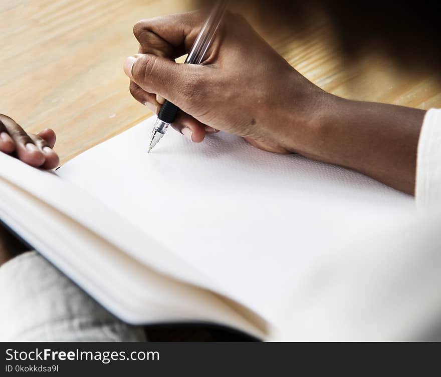 Person Uses Pen on Book