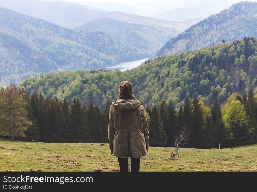 Photo of Woman Wearing Jacket Standing Near Forest Trees