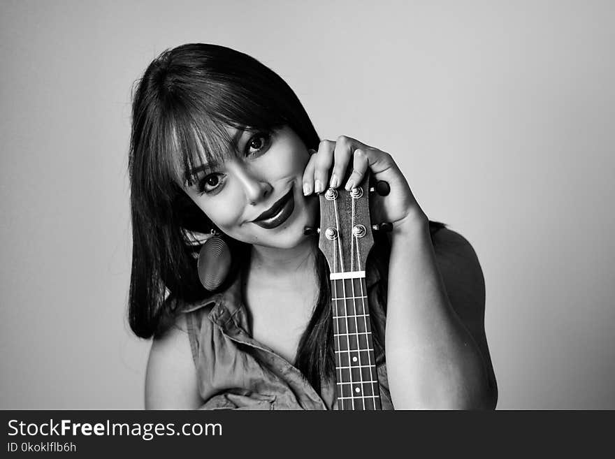 Photography of a Woman Holding Ukelele