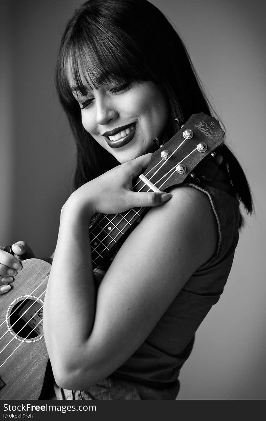 Greyscale Photo of Woman Holding Ukulele