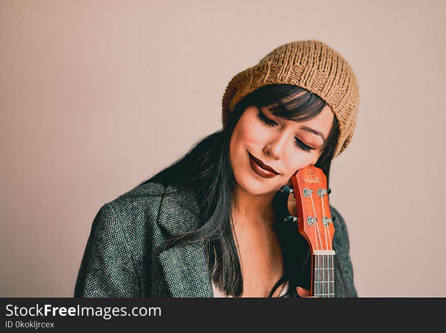 Photography of a Woman Holding Ukelele