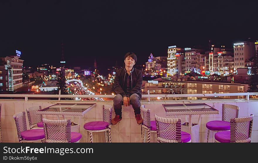 Man Sitting on Hand Rail