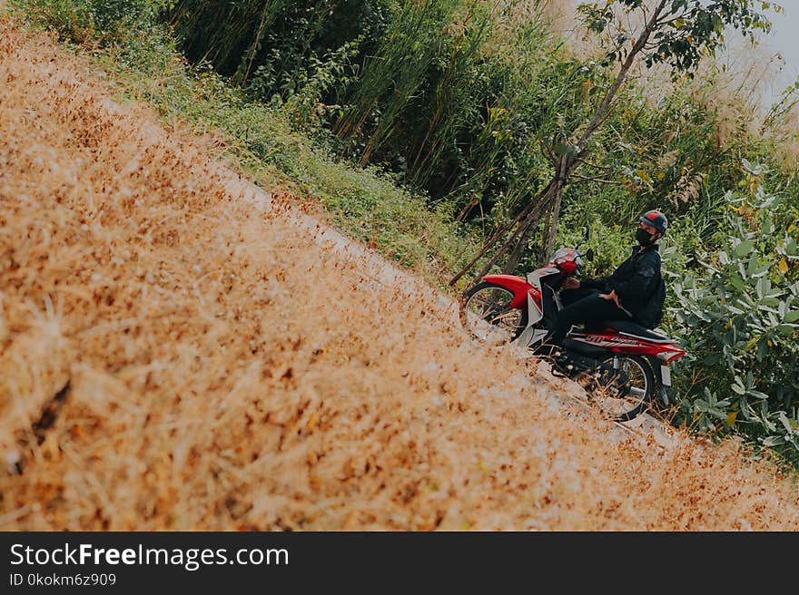 Man on White and Red Underbone Motorcycle