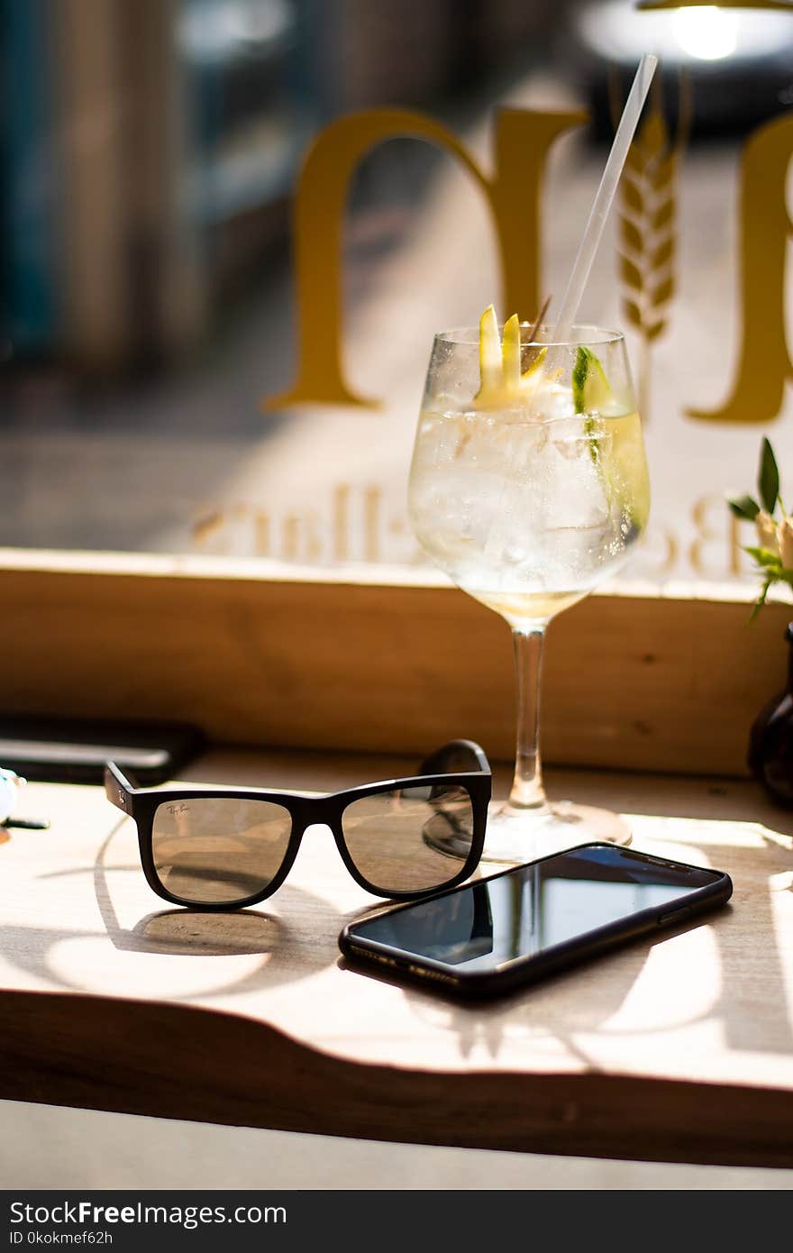 Wine Glass Beside Android Smartphone and Sunglasses