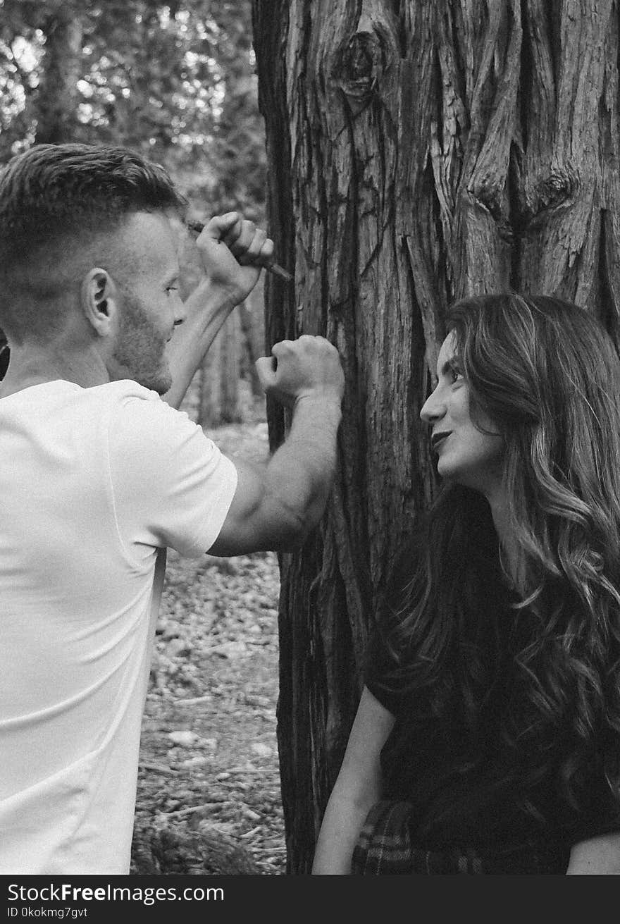 Monochrome Photography of Man and Woman Near Tree