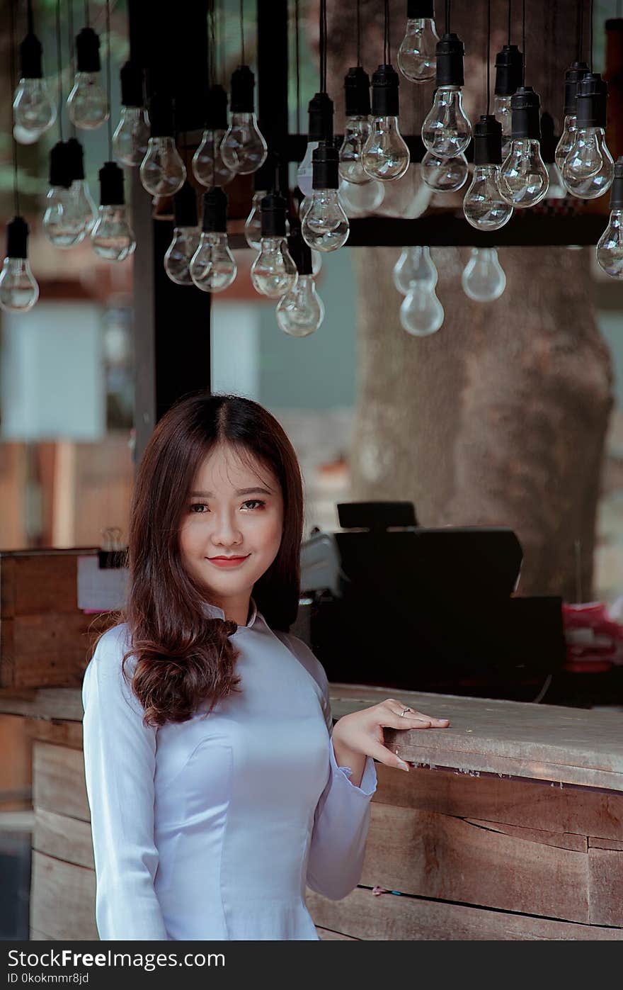 Photography of a Woman Near Light Bulbs