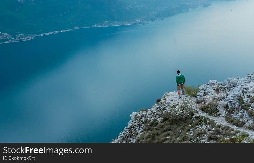 Photo of Man Standing on Cliff