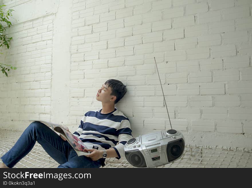 Photo of Man Sitting Near Radio