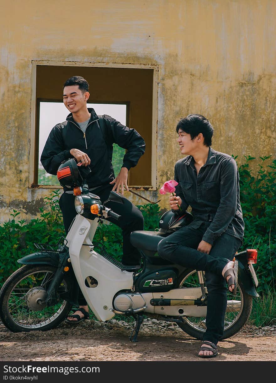 Two Man Standing Near White and Black Underbone Motorcycle