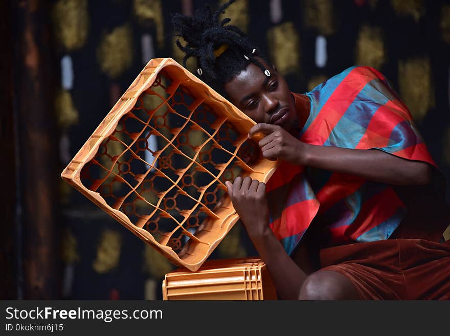 Photography of a Guy Leaning on Plastic Bottle Crate