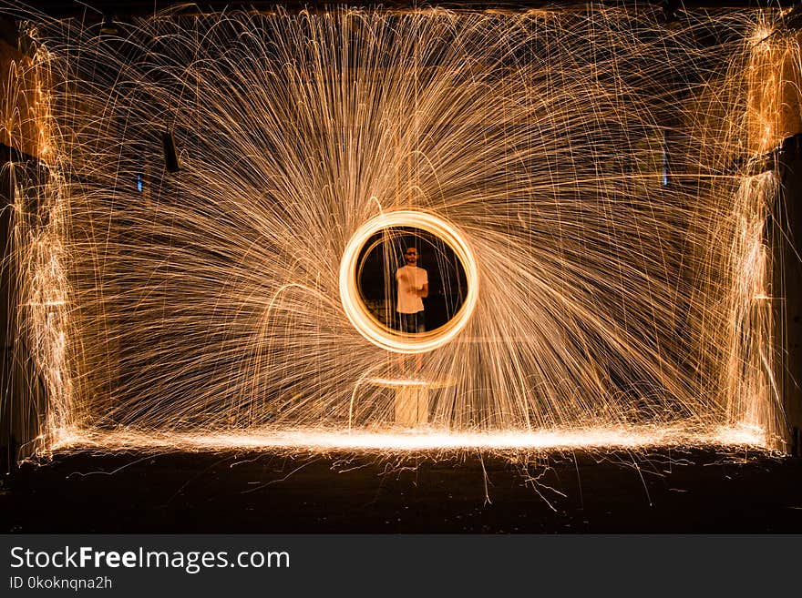 Yellow Sparks in Front of Person in White Top