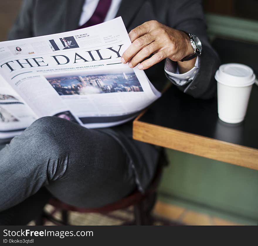 Photography of a Person Reading Newspaper