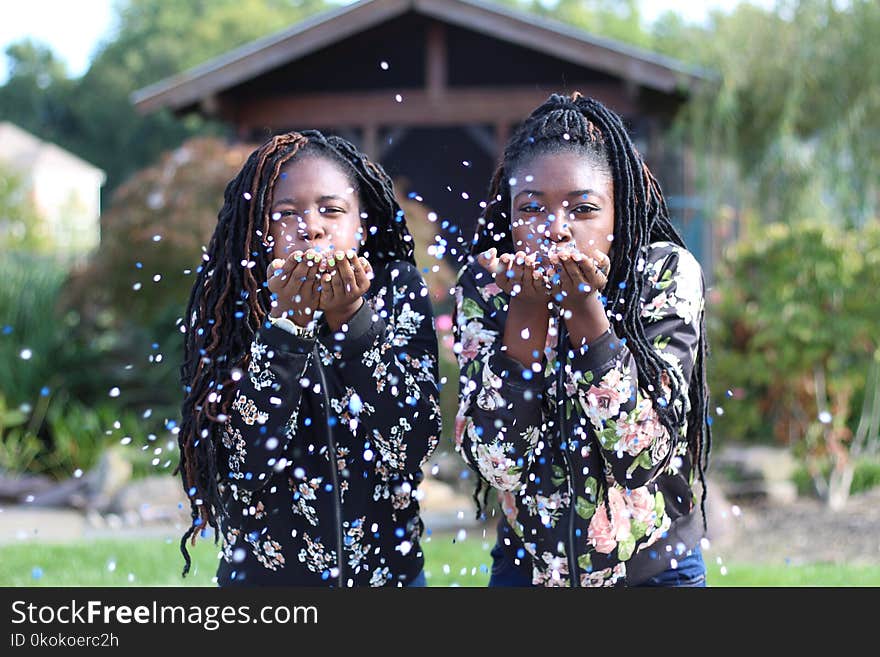 Two Woman Blowing Flower Petals