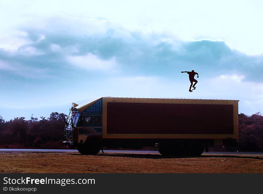 Brown Truck With Man With Skateboard on Top