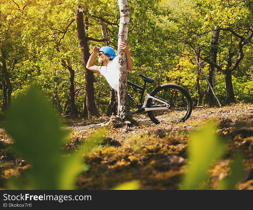 Photo of Person Wearing White T-shirt Holding Tree Trunk