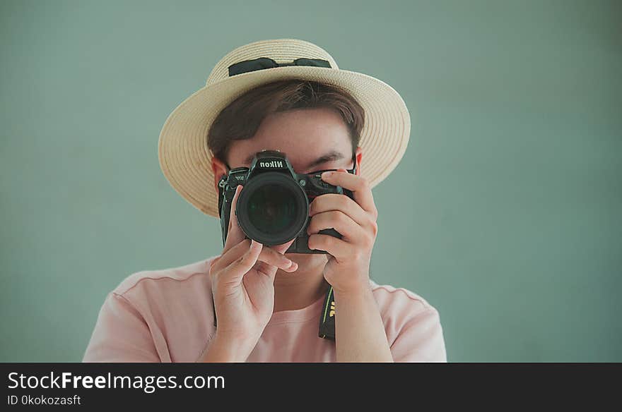 Man in Pink Shirt Holding Dslr Camera