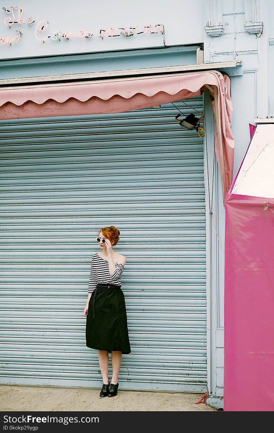 Woman Wearing Black And White Stripe Off-shoulder Dress Standing Near Roll-up Door