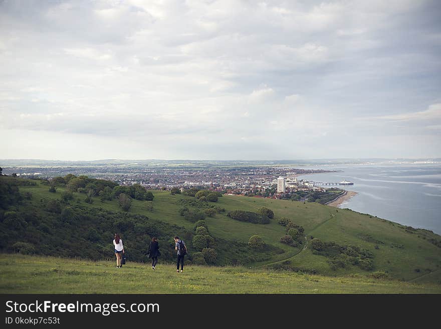 Three People Standing on Grassfield